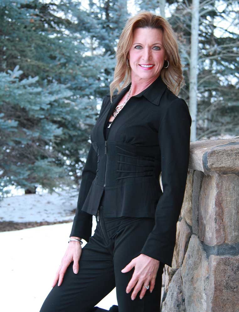 A smiling woman in a black suit posing for a photo